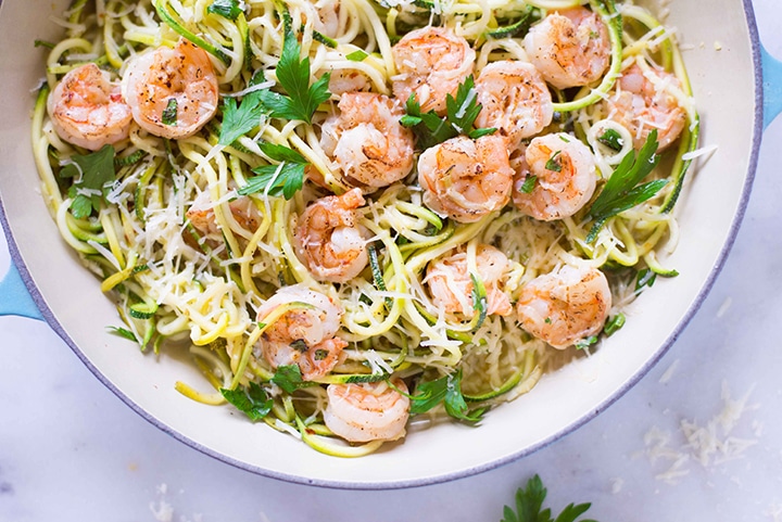 Close up image of the shrimp scampi, with cooked shrimp, which has been seasoned with sea salt, garlic, pepper, and crushed red pepper flakes. Also cooked are the freshly spiralized zucchini noodles.