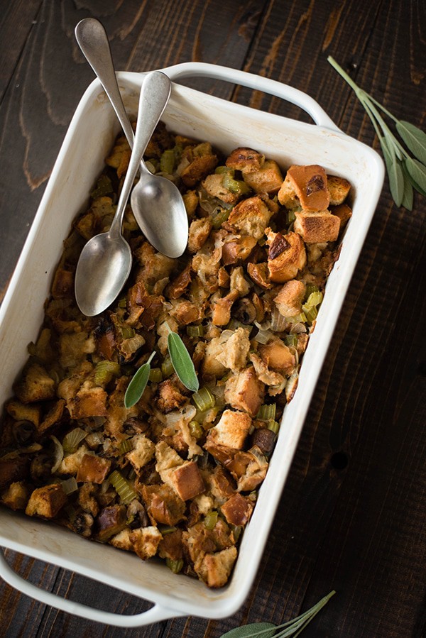 Overhead view of a loaf dish filled with Thanksgiving Stuffing. Two silver spoons are laying on the stuffing.