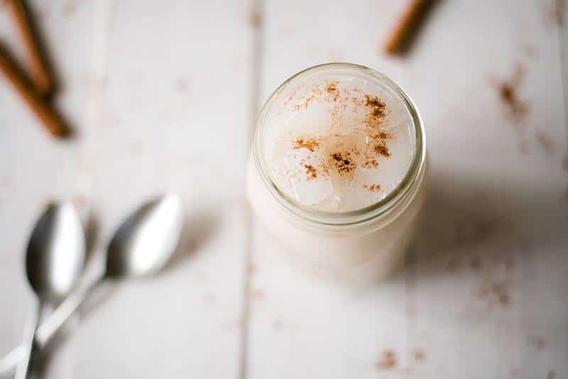 Overhead shot of horchata recipe served in a mason jar and garnished with ground cinnamon 