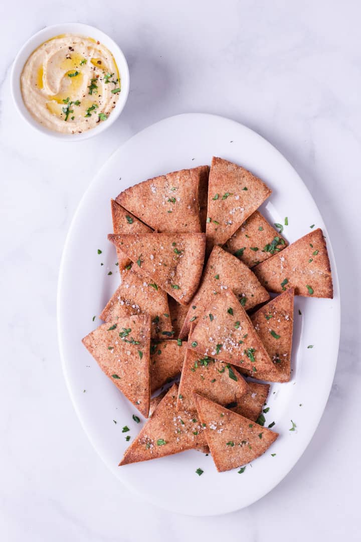 Looking for a healthy version of crunchy pita chips? This recipe for easy homemade baked pita chips is the best way to satisfy your snack craving! They’re totally dippable, too!