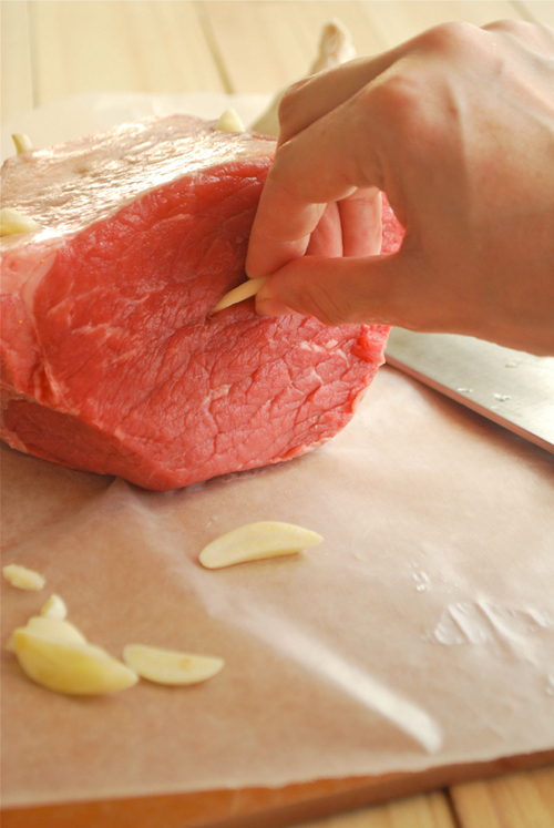 Image demonstrating how to insert thinly sliced garlic cloves into the raw roast beef prior to cooking to flavor the roast beef recipe.