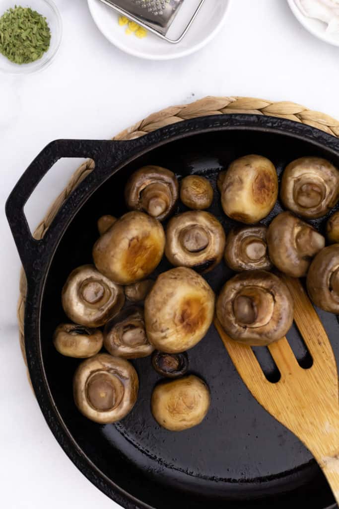 Overhead view of a skillet of marinated mushrooms.