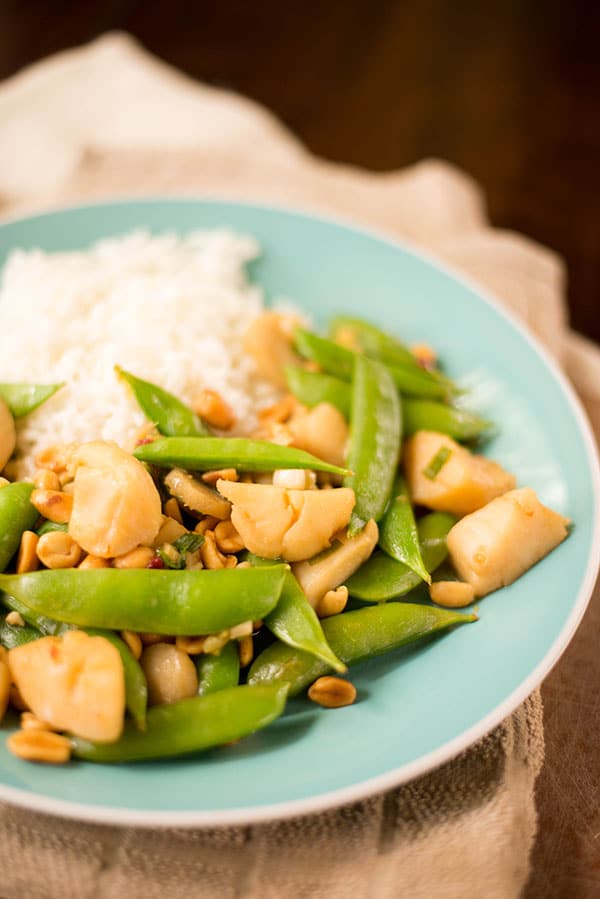 Image of Kung Pao Scallops, on a blue plate, served with rice and vegetables and ready to eat.