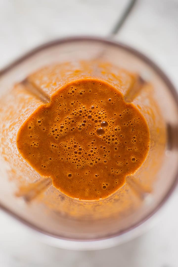 Overhead view of a blender with the blended homemade enchilada sauce, ready to be used in the shredded chicken enchiladas.
