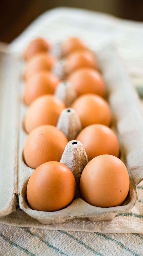 Close of view of an open carton of 12 brown eggs.