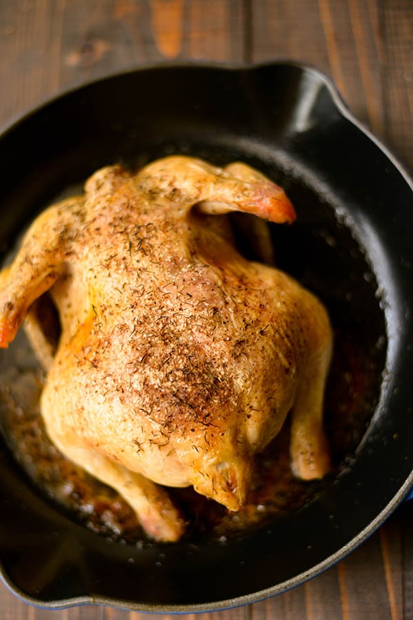 Overhead image of the Healthy Oven Roasted chicken in the oven-proof skillet, ready to cool and slice.
