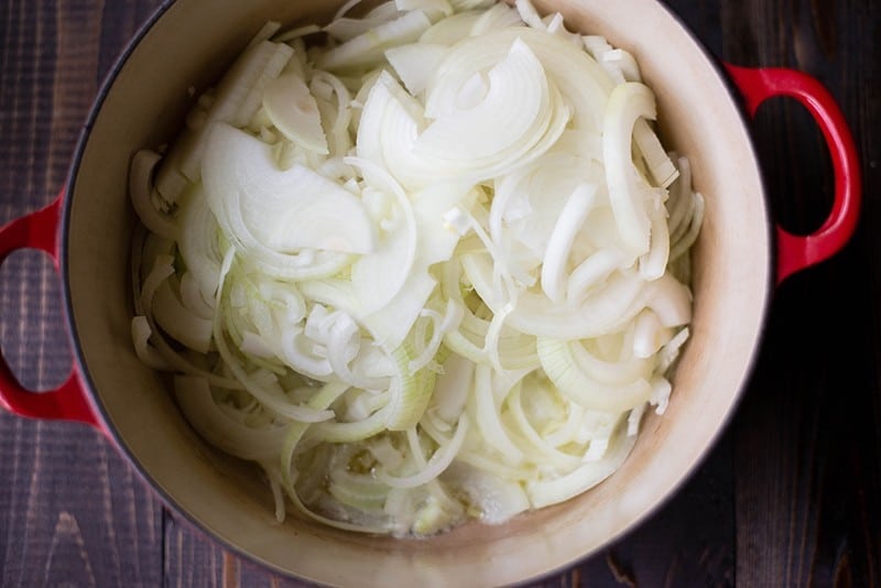 Sliced onions in a ceramic pot, ready to be used in Healthy French Onion Soup.