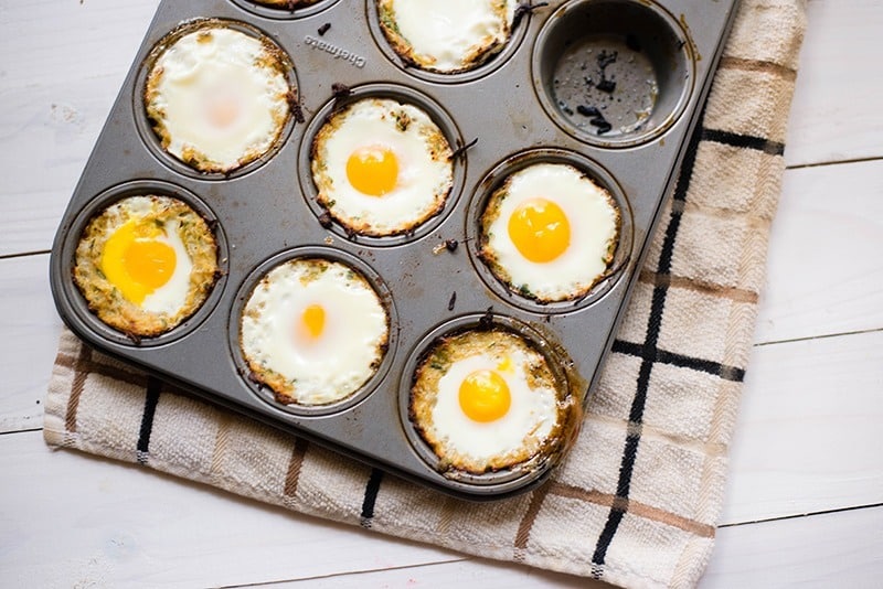 Baked eggs in squash nests, fresh out of the oven and ready to be plated and removed from the muffin tin.