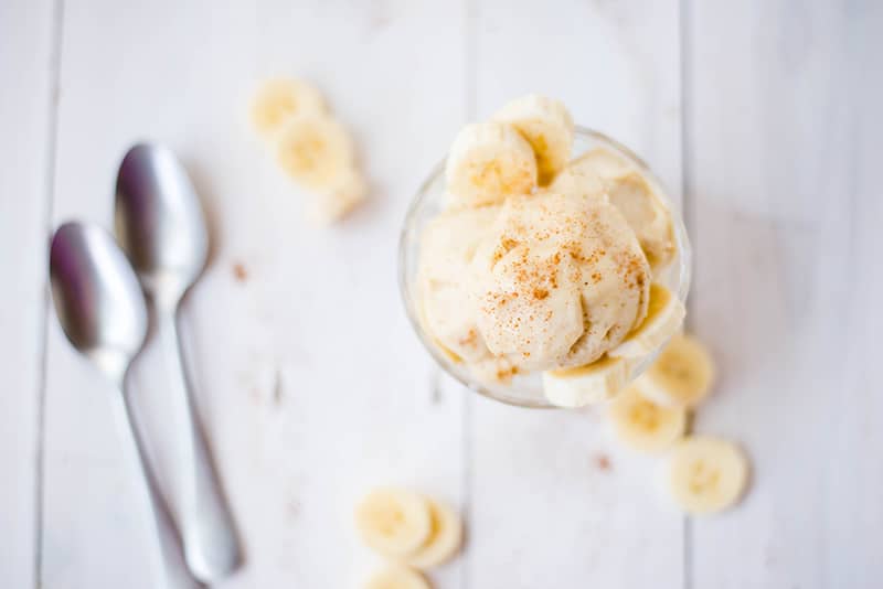 Overhead photo of homemade banana ice cream served in a bowl and garnished with cinnamon 