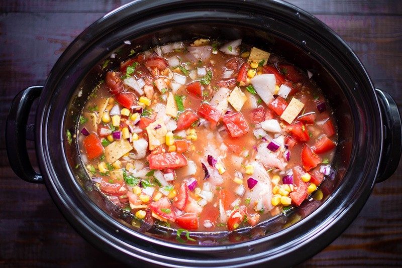 Overhead view of the pot of Slow Cooker Chicken Tortilla Soup, cooked in the slow cooker and ready to dish up.