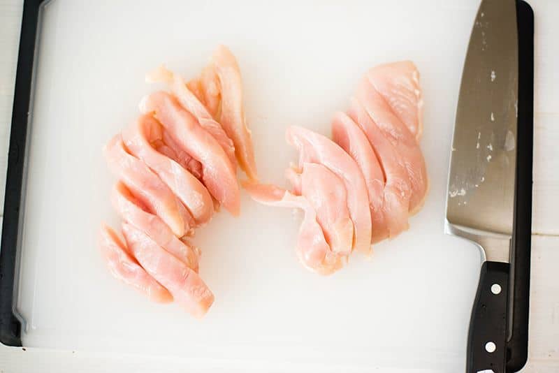 Uncooked chicken breasts cut into strips for baked almond chicken strips recipe 