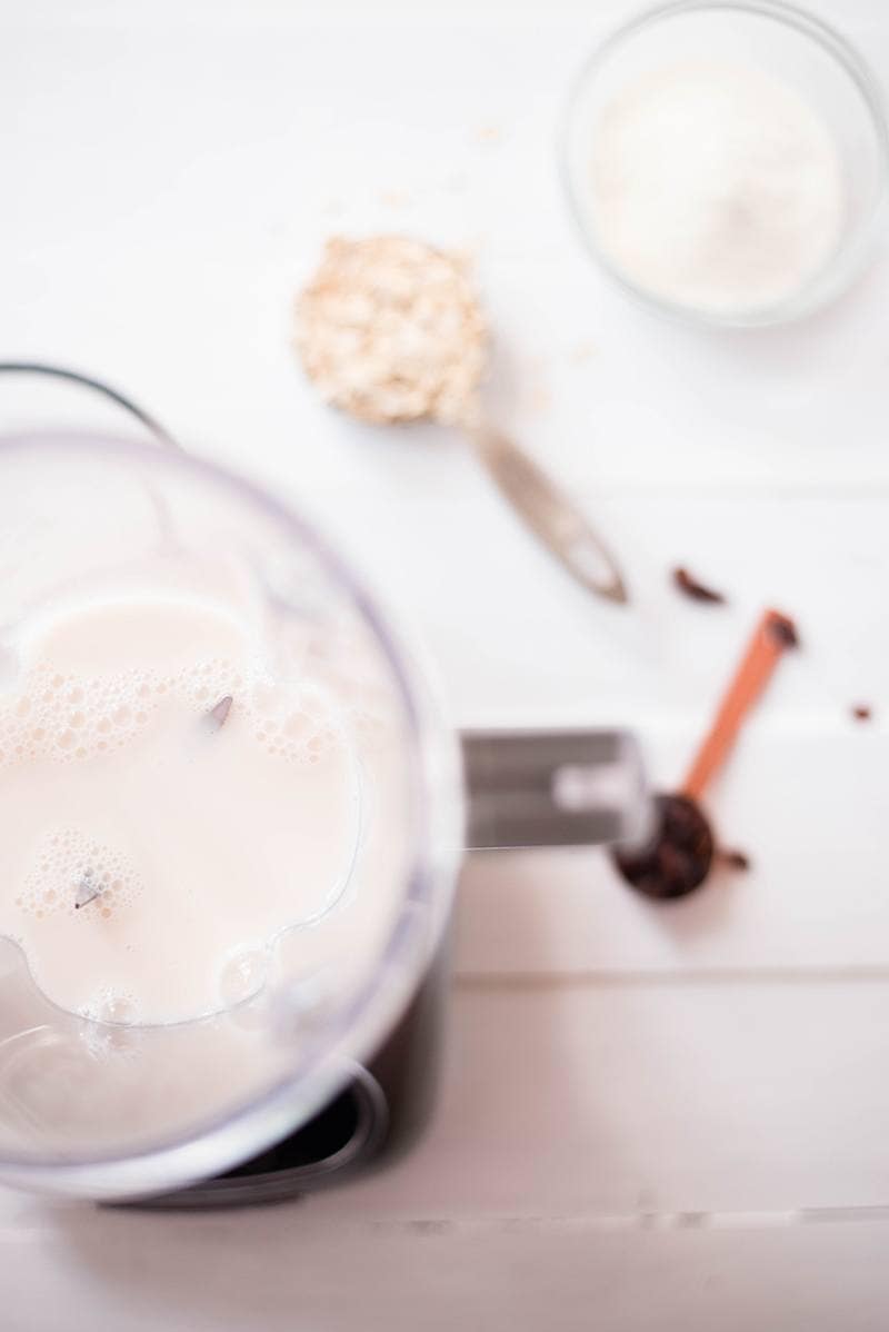 Almond milk poured into a blender to make oatmeal raisin cookie protein shake 