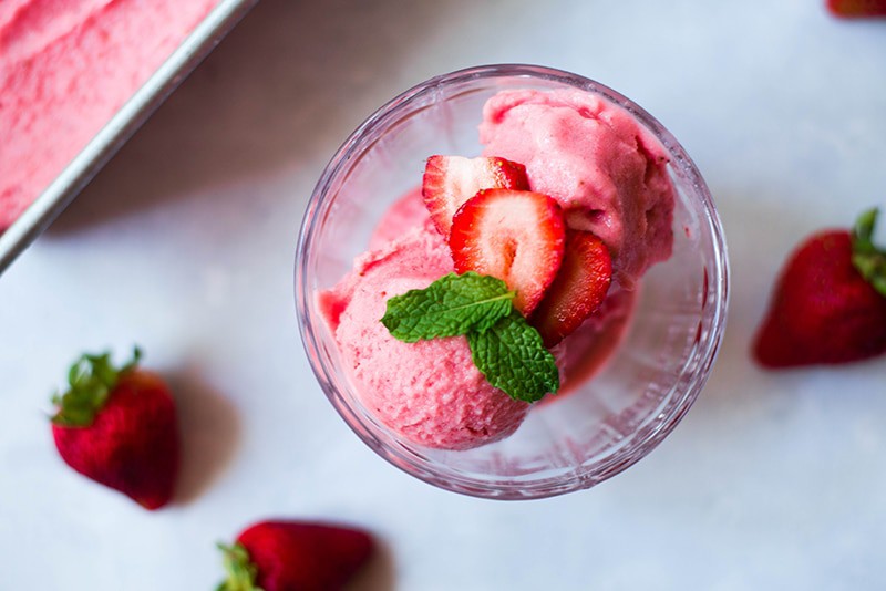 4 ingredient strawberry frozen yogurt garnished with fresh mint leaves and strawberries 