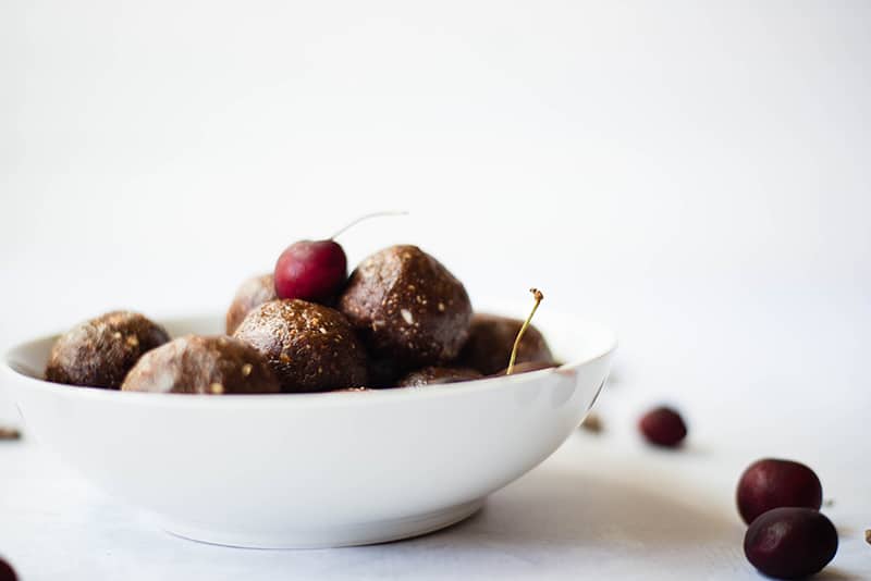 Side angle photo of a bowl of dark chocolate energy bites, ready to be served and enjoyed 