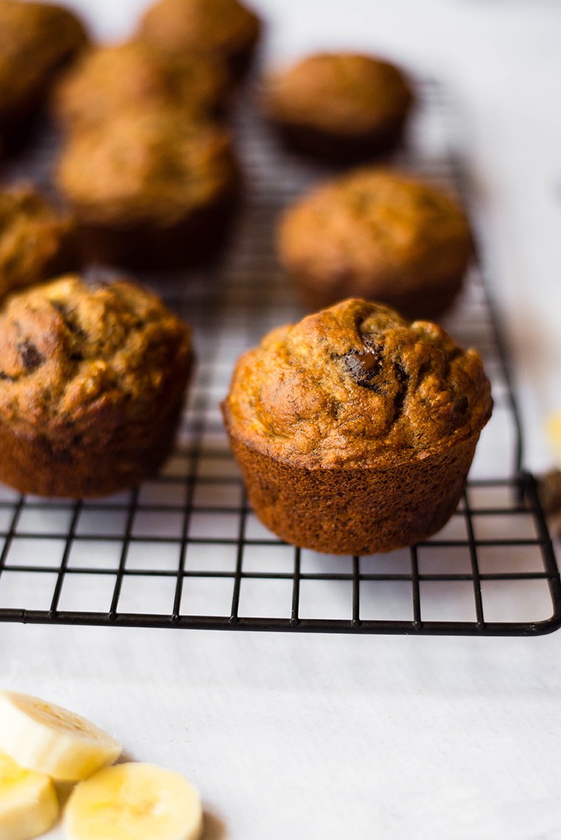 Baked healthy banana chocolate chip muffins removed from the oven and cooling on a colling rack, ready to eat.