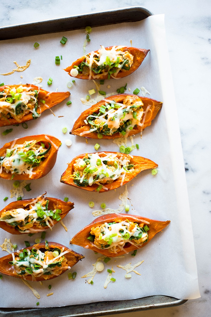 Looking for a potato skins recipe that satisfies your craving for a cheesy appetizer? The Best (Healthy) Sweet Potato Skins are nutritious little boats filled with all kinds of good stuff like chicken, spinach, and Greek yogurt. To top it off, they are easy to make and absolutely delicious!