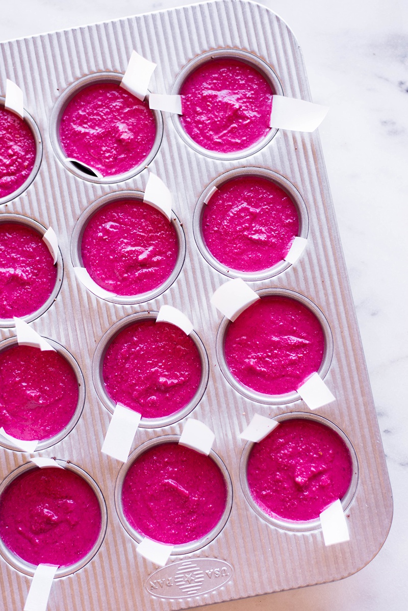 Overhead view of a muffin pan filled with the raspberry beet mini cheesecake and ready to be transferred to the freezer to freeze.