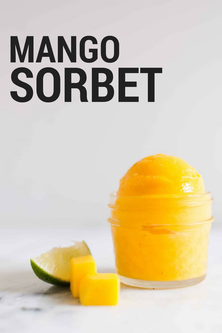 4-oz. mason jar filled with mango sorbet with fresh mango and lime wedge setting next to it.
