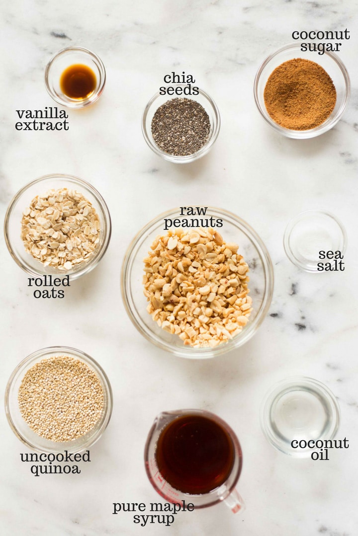 Ingredients separated out for the quinoa peanut brittle, including the uncooked quinoa, vanilla extract, pure maple syrup, raw chopped peanuts, sea salt, coconut sugar, rolled oats, and coconut oil.