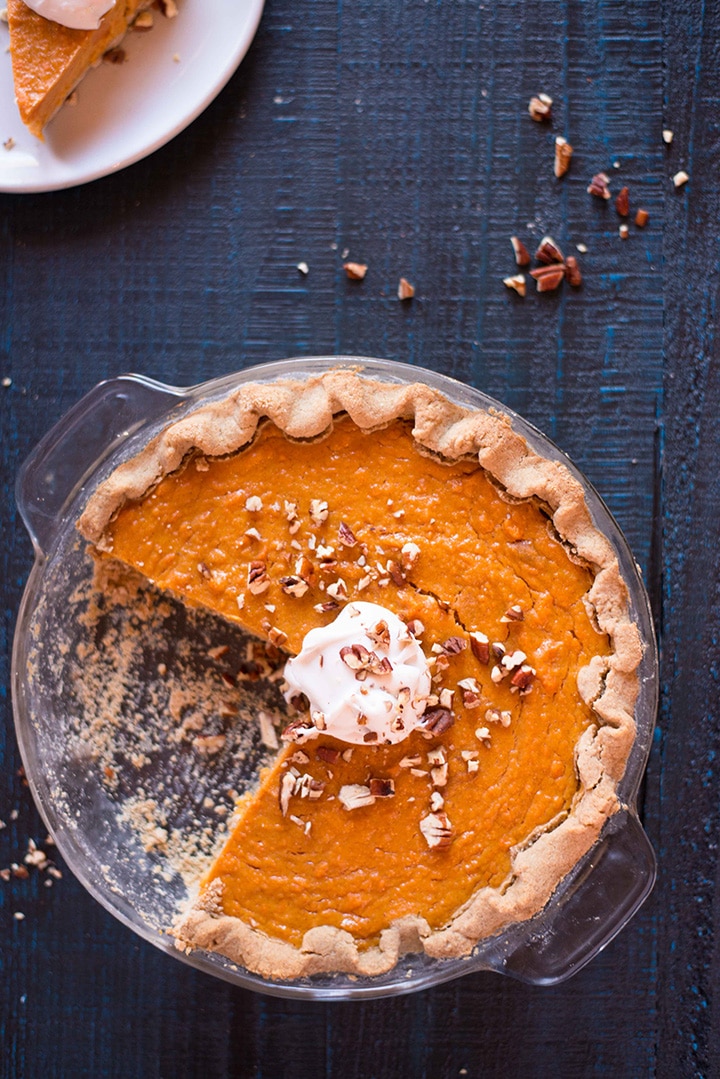 Overhead image of a Southern Sweet Potato Pie in a glass pie dish with a couple of slices of pie taken out.