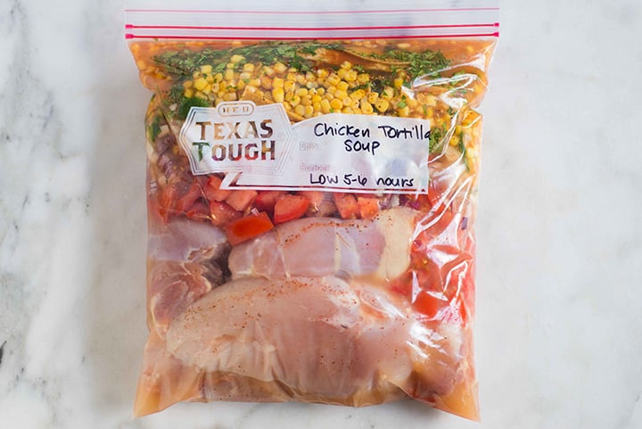 Slow cooker freezer meal in a ziploc bag containing all the ingredients for a slow cooker chicken tortilla soup.