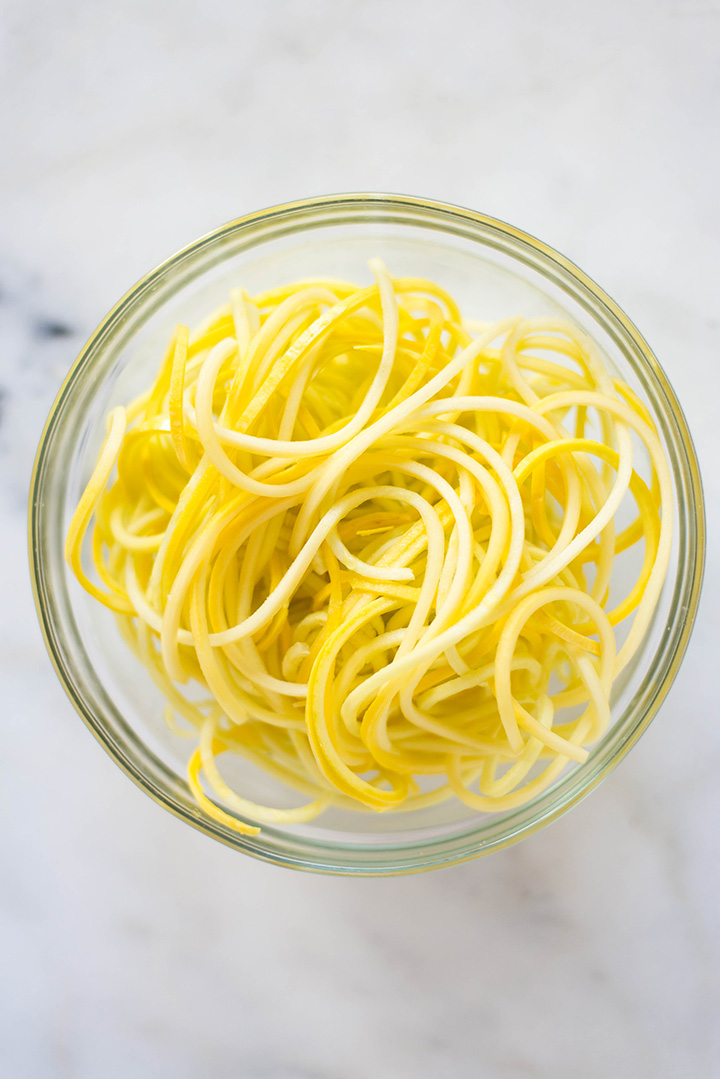 Bowl filled with spiralized yellow squash noodles to show spiralizer veggie recipe.