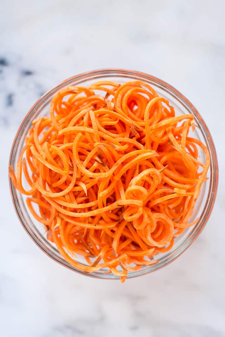 Bowl filled with spiralized sweet potato noodles to show spiralizer veggie recipe.