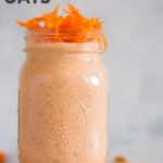 Horizontal view of a jar with Carrot Cake Overnight Oats with rolled oats, carrots, golden raisins, ground cinnamon, chia seeds, pure maple syrup, vanilla, plain greek yogurt and almond milk, topped with shredded carrots