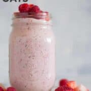 Horizontal view of a jar with Strawberry Overnight Oats with rolled oats, chopped strawberries, raspberries, chia seeds, pure maple syrup, vanilla, plain greek yogurt and almond milk, topped with sliced strawberries