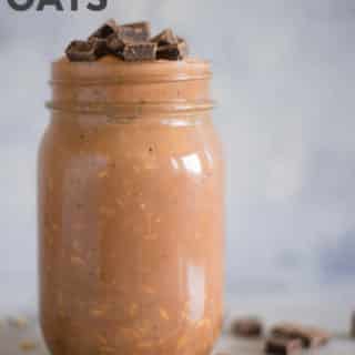 Horizontal view of a jar with Chocolate Peanut Butter Overnight Oats with rolled oats, banana, dark cocoa powder, natural peanut butter, maple syrup, vanilla, plain greek yogurt and almond milk, topped with chocolate pieces