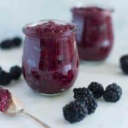 A side image of a glass jar filled with Homemade Blackberry Chia Jam made from fresh blackberries, chia seeds, and raw honey.