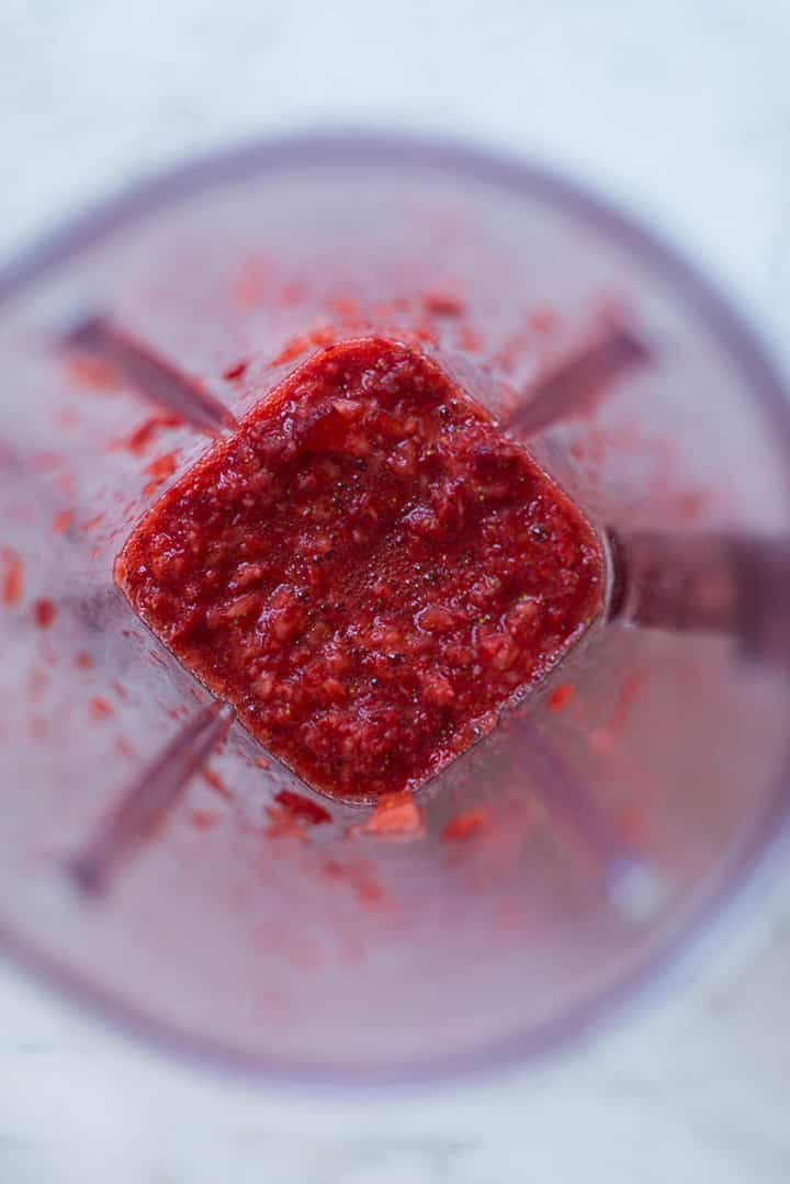 An overhead image of a blender with strawberry puree for the Homemade Strawberry Soda.