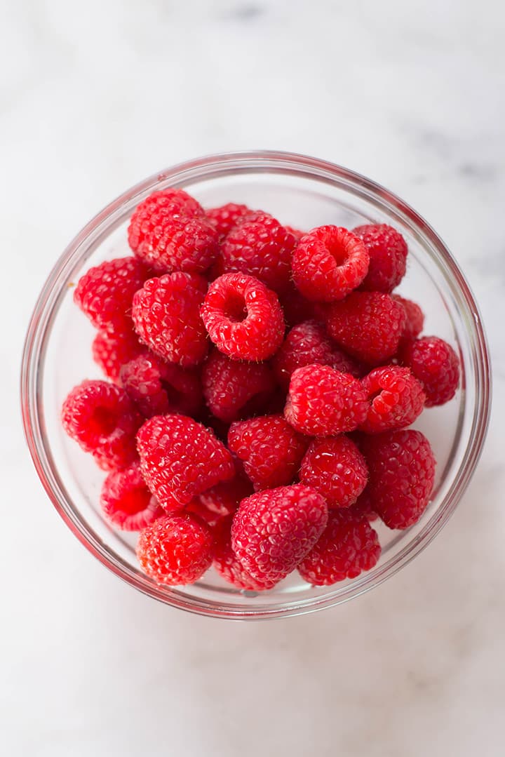 An overhead image of a bowl of fresh raspberries ready for the Raspberry sorbet.