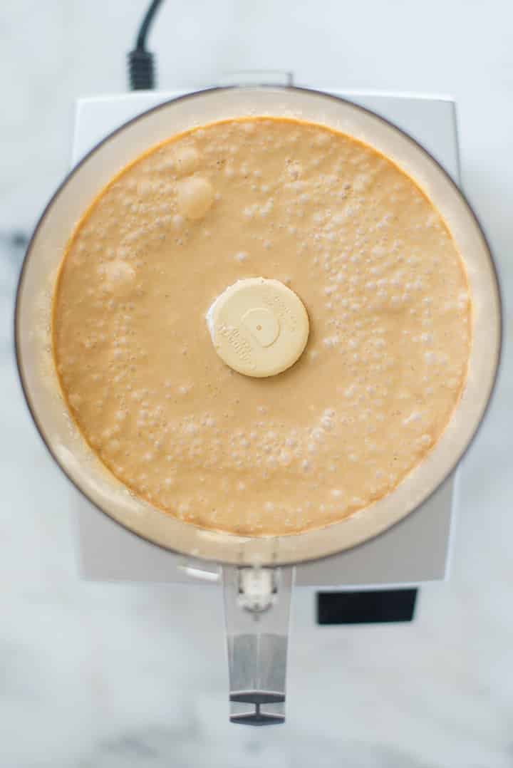 An overhead image of a blender with all the blended ingredients for Coffee Ice Cream including full fat coconut milk, pure maple syrup, brewed and chilled strong coffee, instant coffee and vanilla extract, ready to be placed in the freezer.