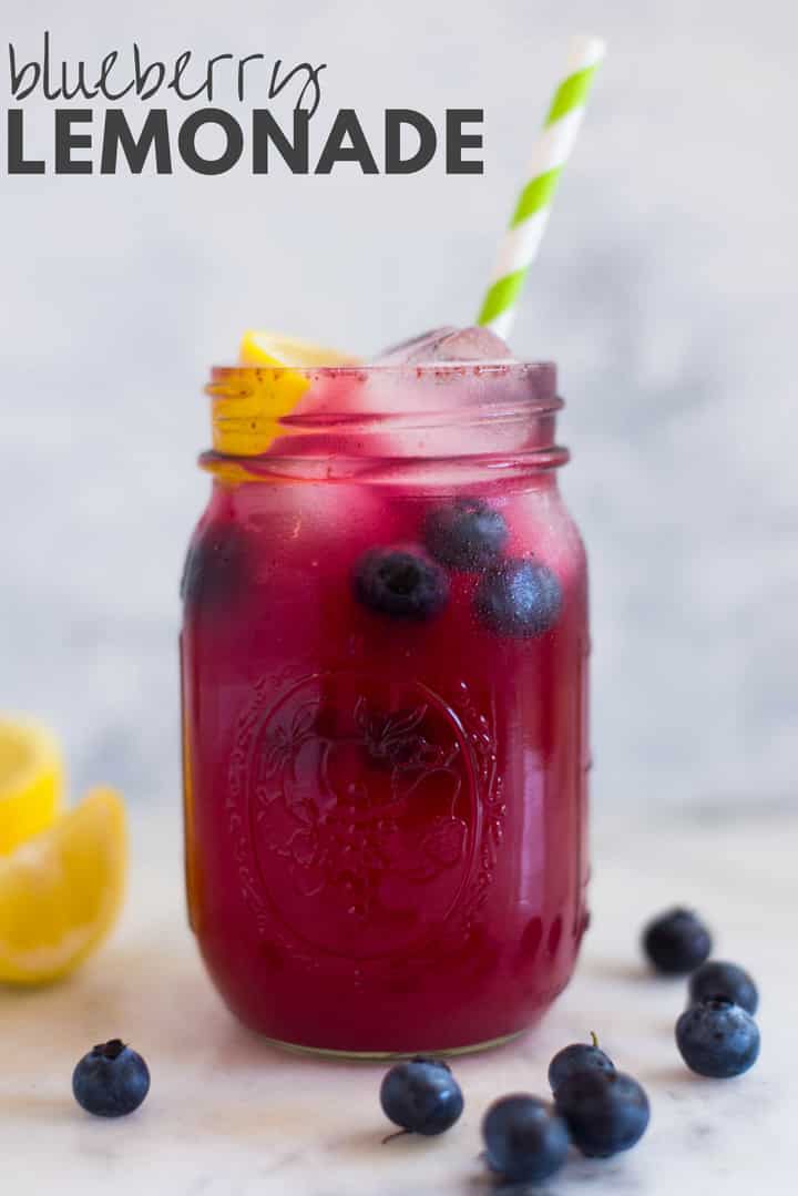 A side image of a mason jar filled with Easy Homemade Blueberry Lemonade, made from fresh blueberries, freshly squeezed lemon juice, water and raw honey, served with a slice of lemon and fresh blueberries.