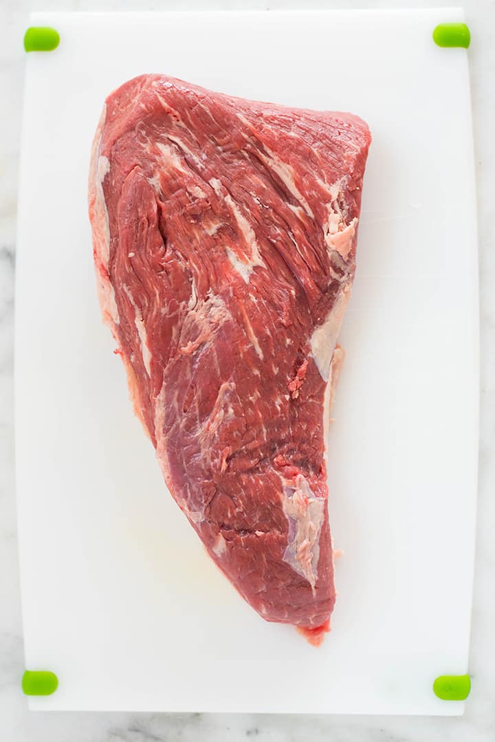 An overhead image of a tri tip steak on a kitchen counter ready to be marinated in a Tri Tip Marinade.