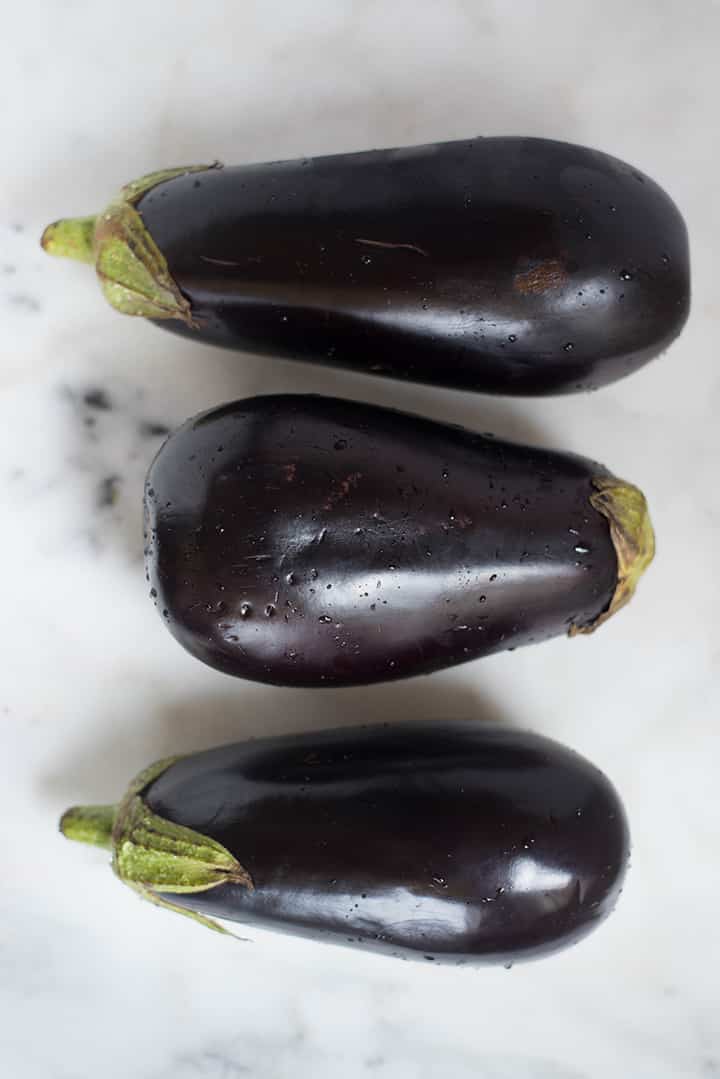 An overhead image of 3 thoroughly washed eggplants on the kitchen counter for the Baked Eggplant Parmesan recipe.