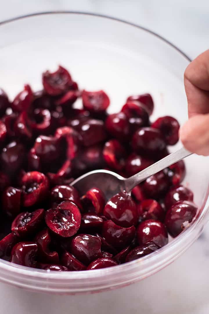 A close up image of a glass bowl with fresh pitted cherries for the Fresh and Healthy Cherry Crisp.