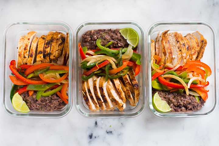 An overhead image of 3 meal prep containers with Healthy Chicken Fajitas made with Fajita Chicken, Fajita Bell Peppers and Lime & Cilantro Black Beans and ready to be stored in the refrigerator.
