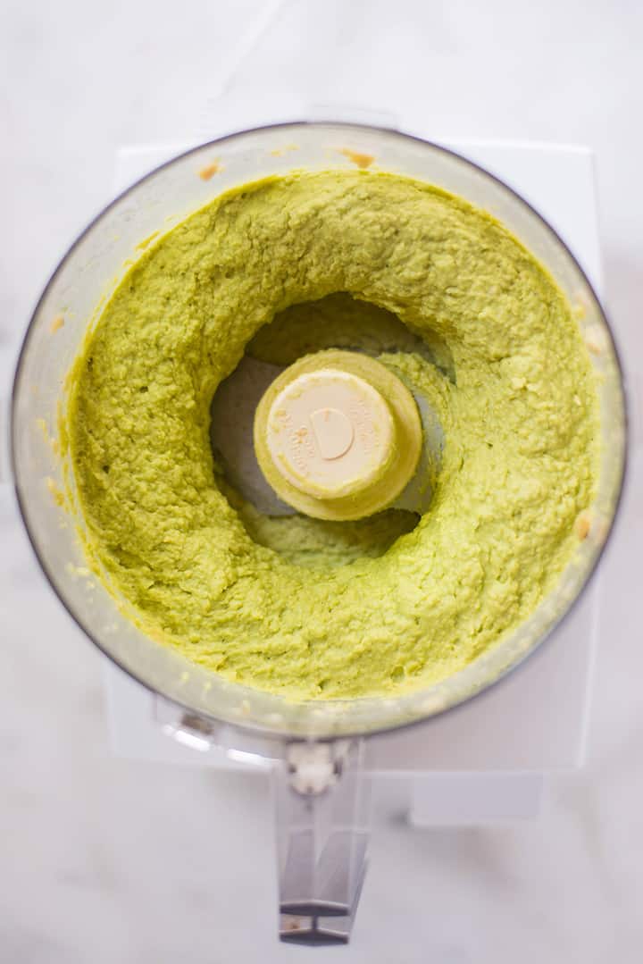 Healthy Avocado Hummus in the food processor ready to be transferred to a serving bowl.