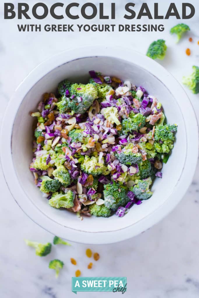 An overhead view of Healthy Broccoli Salad with Greek Yogurt Dressing, in a white bowl and including raisins, almonds, cabbage, and sugar-free uncured bacon.