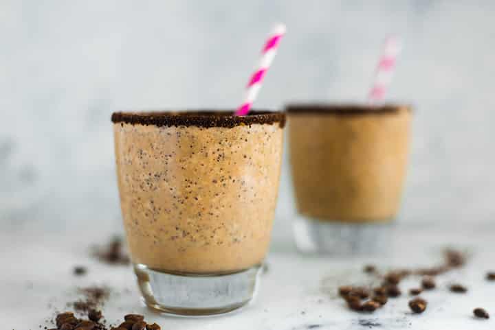 Side view of 2 glasses of Healthy Coffee Smoothie, prepared and ready to drink and each one with a striped straw..