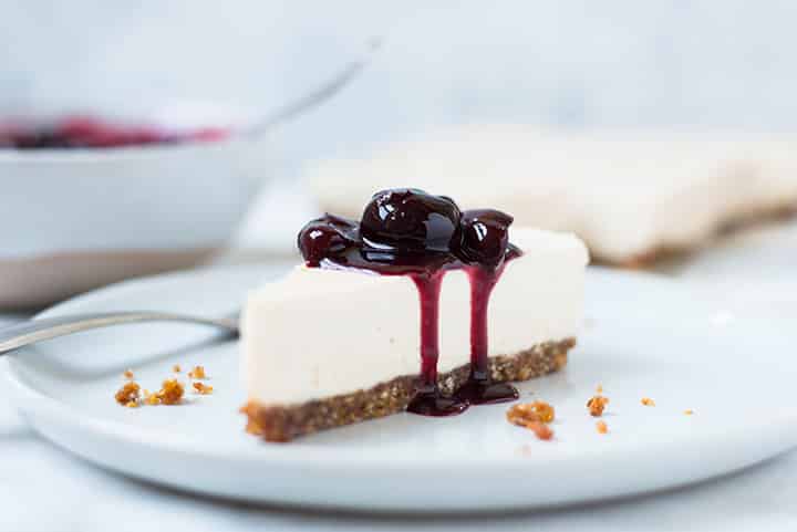Side view of the Healthy No Bake Cherry Vegan Cheesecake on a serving plate.