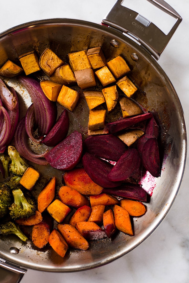 Searing the vegetables for the Healthy Harvest Buddha Bowl in a pan before transferring them to the oven for roasting.
