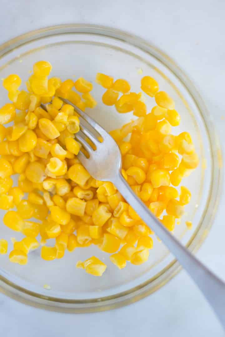 A mixing bowl with fresh corn in it. The corn will be used in the Easy Sweet Cornbread Recipe.