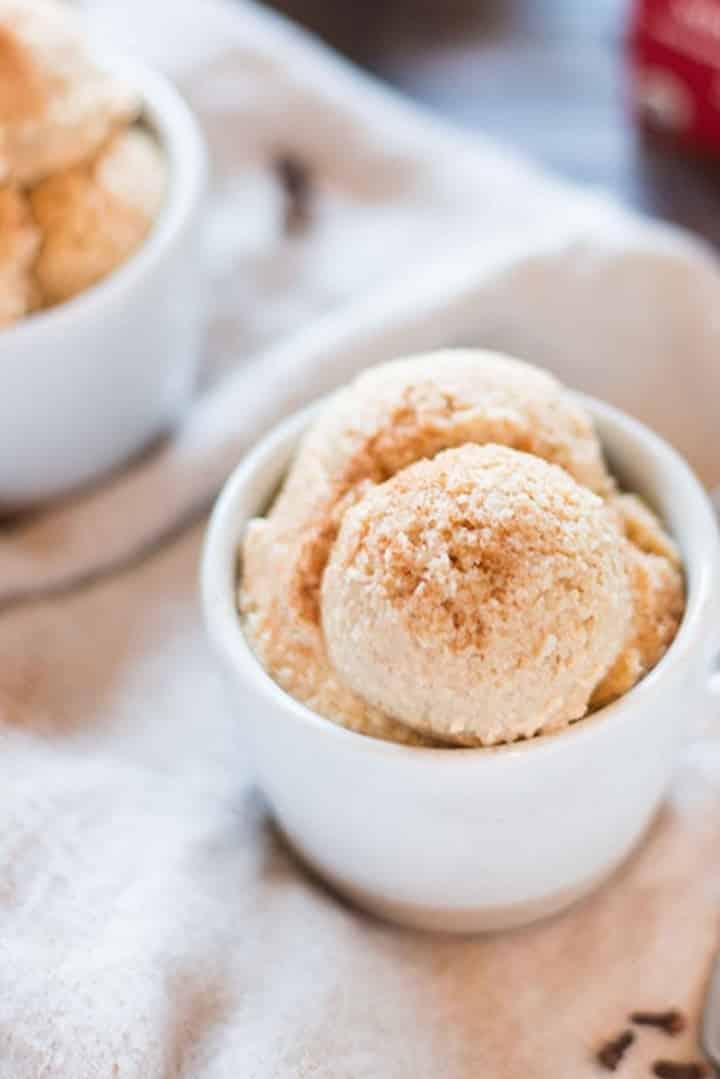 Two servings of eggnog ice cream, each with two scoops, and topped with ground cinnamon.