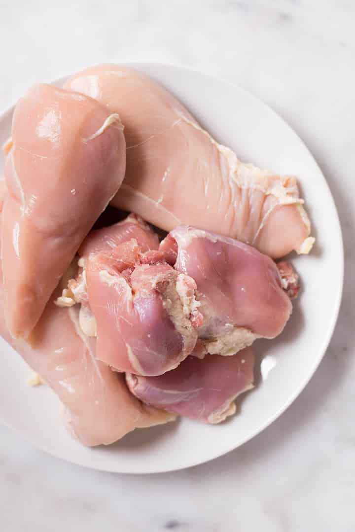 Unseasoned chicken breast and chicken thighs that will be used to make Slow Cooker Shredded Chicken.