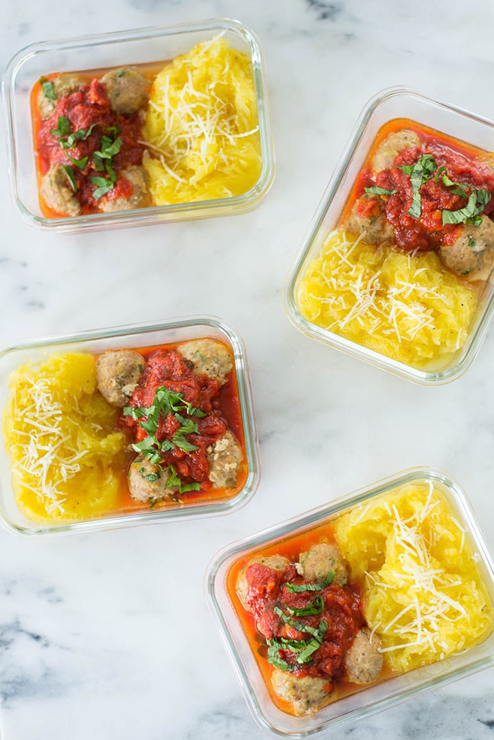 Top view of 4 meal prep containers filled with Turkey Meatballs with Spaghetti Squash Noodles.