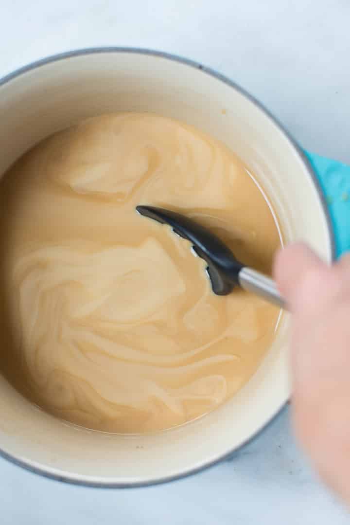 Combining the vanilla latte ingredients including espresso, vanilla extract, almond milk, coconut milk, and pure maple syrup in a saucepan over medium high-heat.