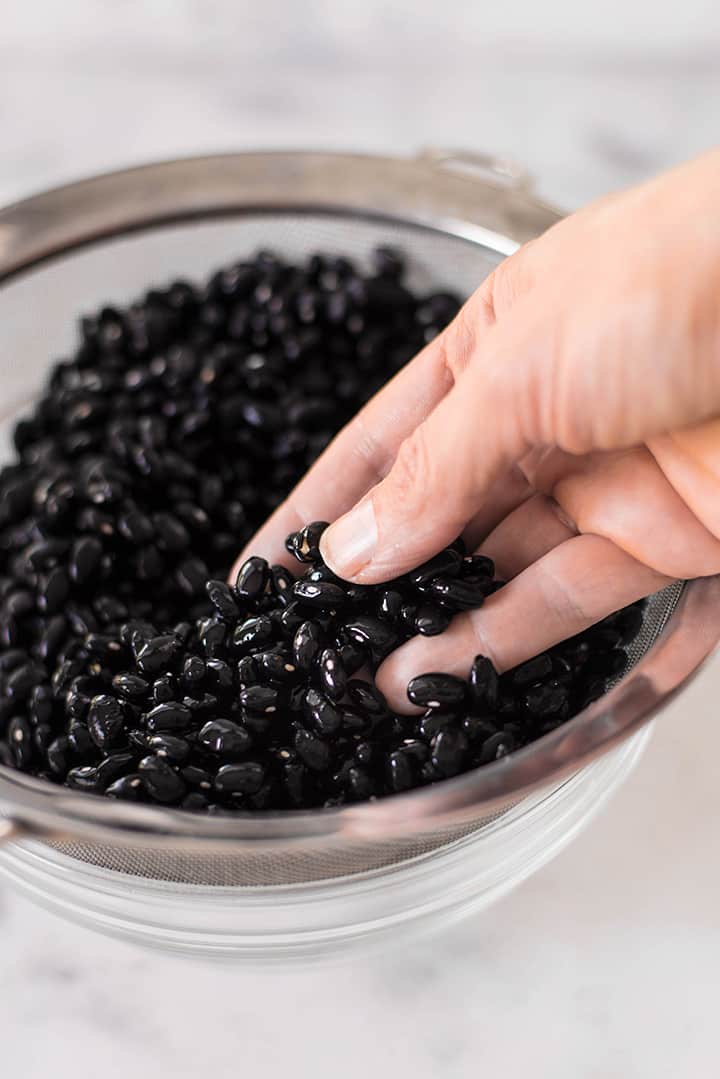 Close up a rinsed black beans in a mixing bowl. The black beans will be cooked in the instant pot.